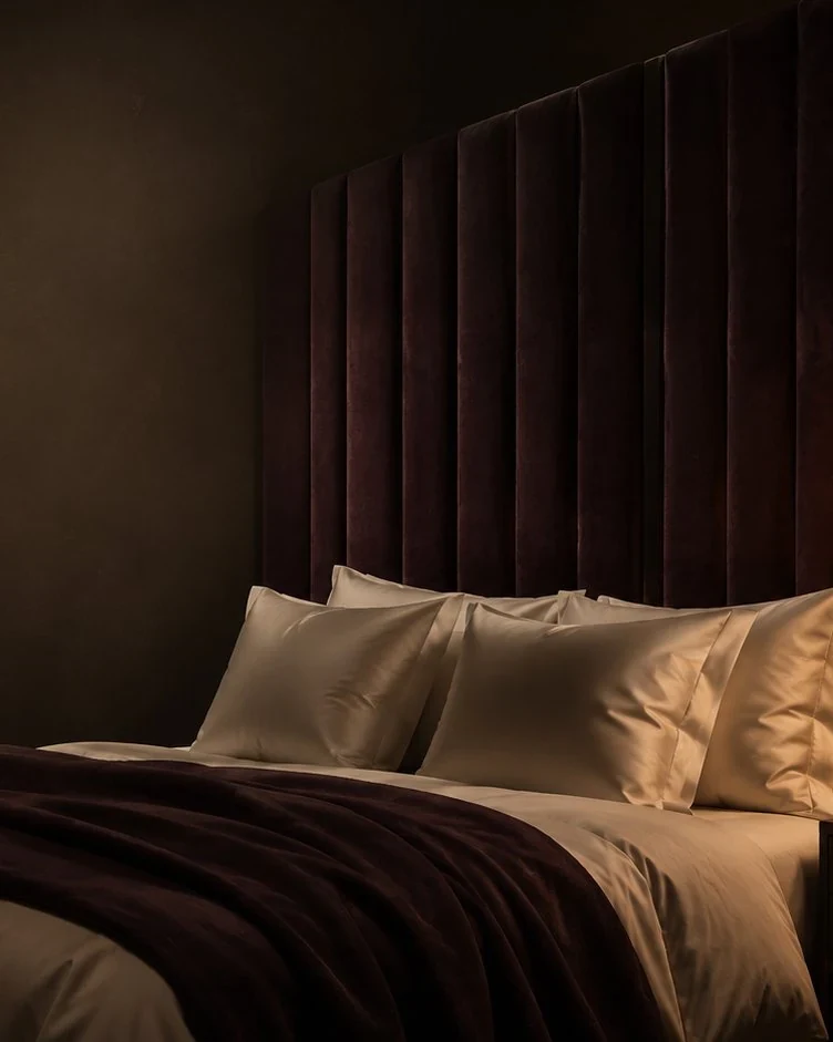 A still life of a brushed brass tray with candle and folded linen in a refined bedroom — the Velqira aesthetic for intimacy at home